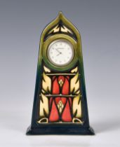A Moorcroft mantel clock, in black glaze with red, cream and green stylised decoration, marked