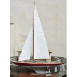 A large wooden pond yacht, having weighted keel, painted off white and burgundy hull, faux plank