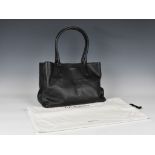 A black leather tote bag by LK Bennett, with two top handles, gold toned hardware, magnetic top