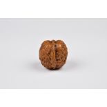 A Japanese carved 'thousand faces' walnut, probably 19th century, 3.7cm. long. * Condition: Good