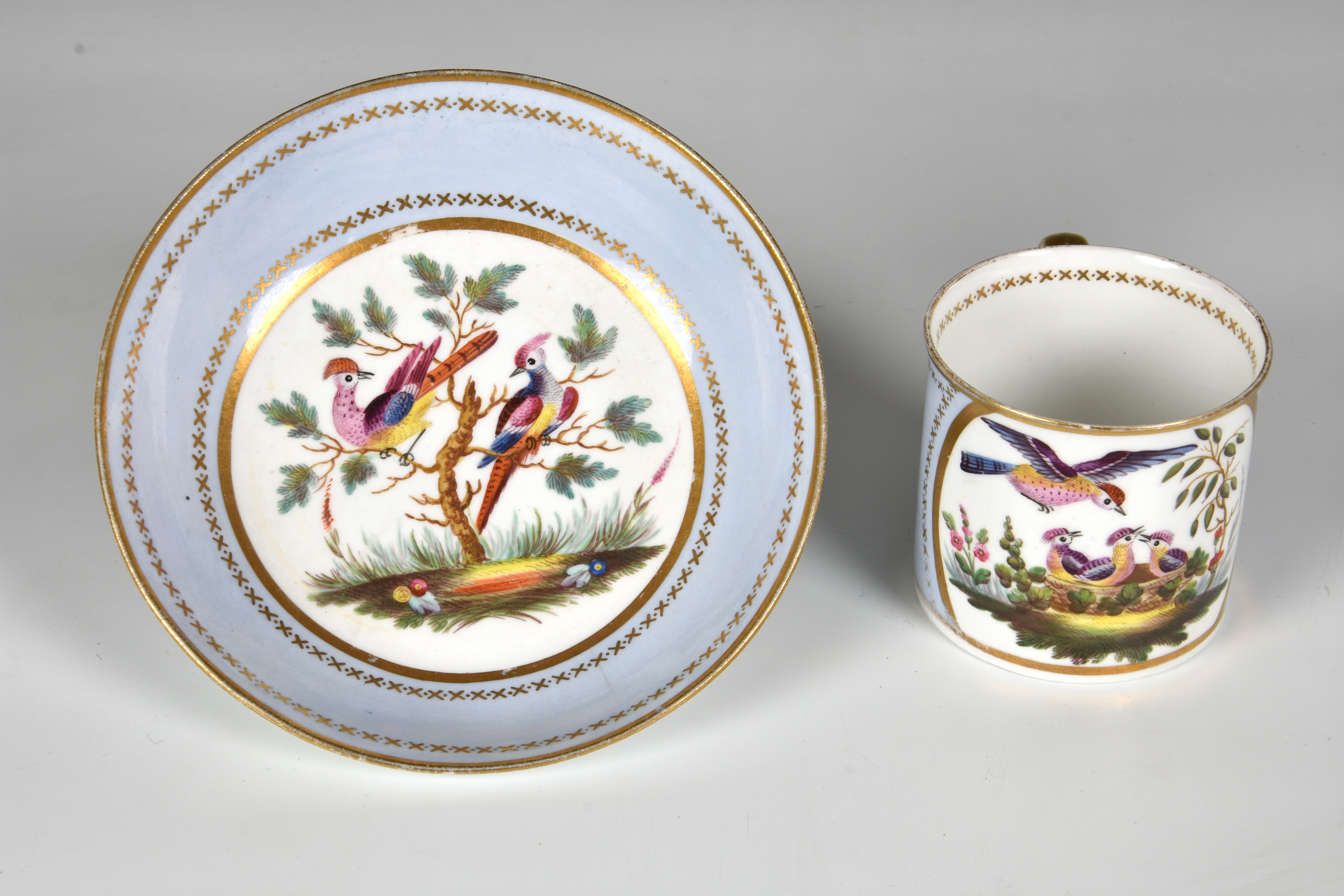 A Spode porcelain coffee can and saucer, early 19th century, with painted reserves of exotic