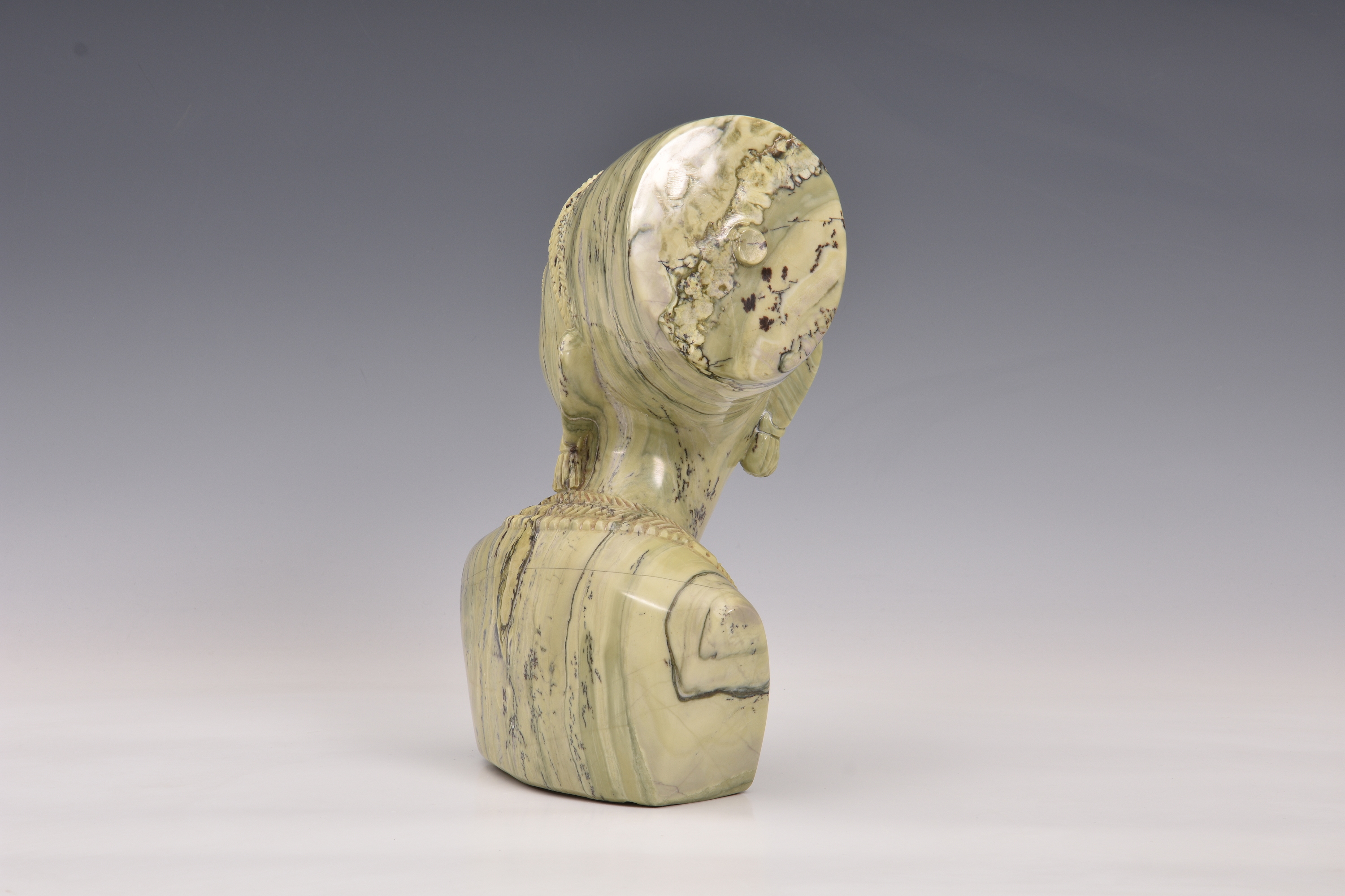 A carved greenstone bust of a young African woman, unsigned, late 20th century, 11¼in. (28.5cm.) - Image 3 of 3