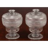 A pair of Georgian cut glass urns and covers, the incuse lower section with facet cutting, the upper
