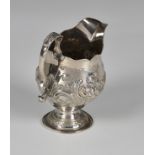 A late-George II silver pedestal cream jug, Walter Brind, London 1758, of bellied form with cut card