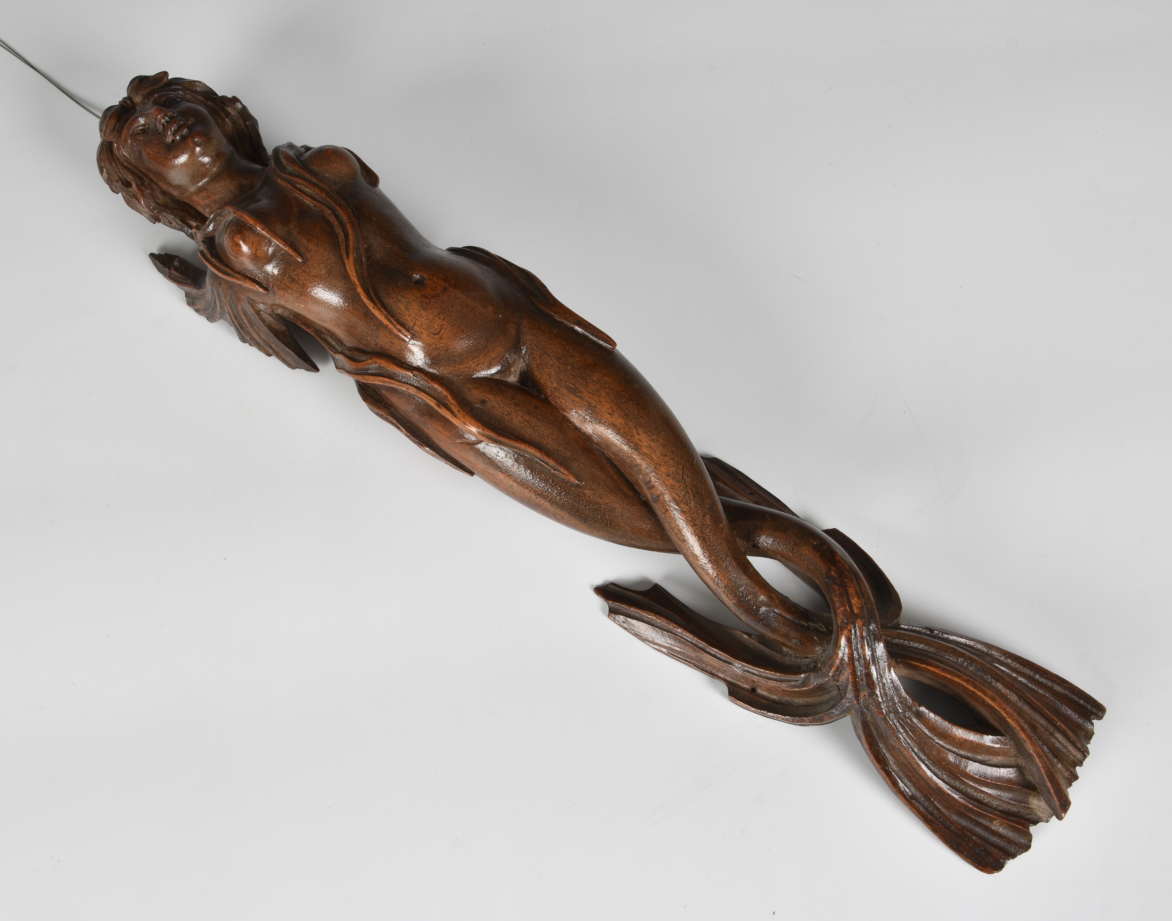 A carved wooden wall applique figure of a mermaid, probably 19th century, with short, fin-style