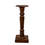 A Victorian style mahogany jardiniére, the square top over a turned and reeded column, on a square