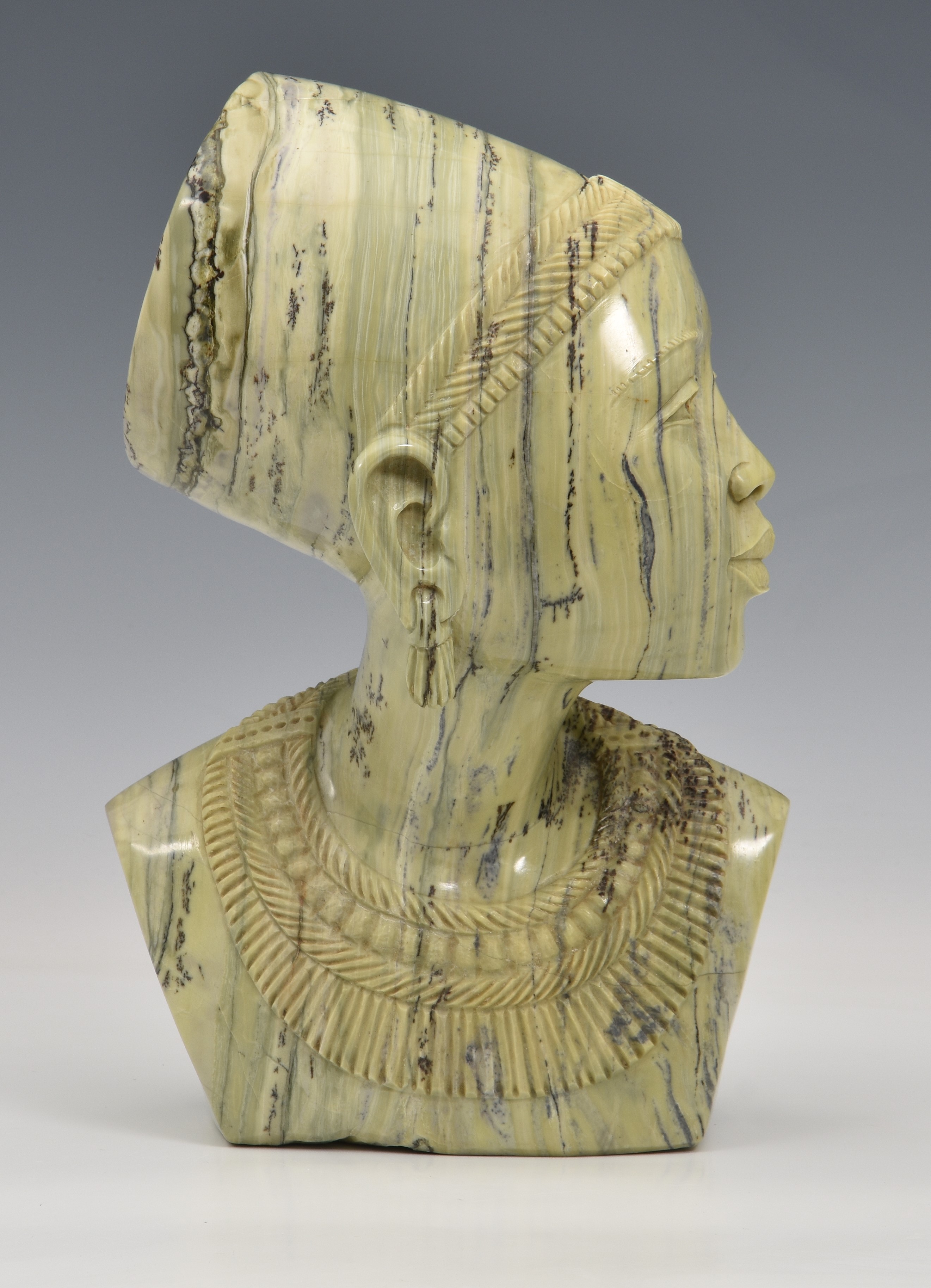 A carved greenstone bust of a young African woman, unsigned, late 20th century, 11¼in. (28.5cm.)