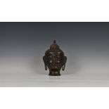 A twentieth century Sino-Tibetan bronze Buddha head, having coral coloured urna to forehead,