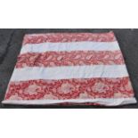 A vintage bed throw, having white and paisley striped detail on red ground, 100 x 84in., together