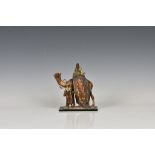 An Austrian Bergman style cold painted spelter table lighter in the form of a camel and two