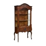 A Louis XV style mahogany display cabinet circa 1920, the flared arched top with floral swag carving