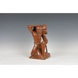 A 20th century Balinese carved wooden figure of a man on one knee, signed beneath "M.D. Panti,