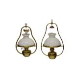 A matched pair of brass and milk glass ceiling oil lamps, the biggest with a drop of 26in. (2)