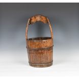 A coopered pine milk pail, 19th century, iron bound, with shaped hooped handle, 22½in. (57.2cm.)