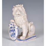 A French faience figure of an armorial lion, probably early 20th century, the seated, white glazed