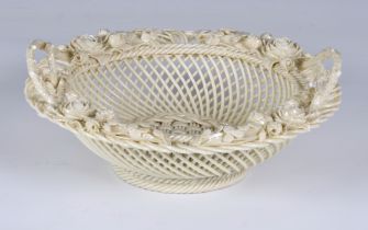 An Irish Belleek pierced circular basket with iridescent glaze, twin double handles, clover leaves