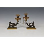 A pair of 19th century patinated and gilt bronze lustre candlesticks, the urn nozzles over pierced
