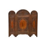 An Oriental hardwood three fold screen, the arched tops with raised foliate border and central