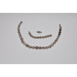 A silver coin necklace and bracelet the necklace made up of twenty nine various graduated silver