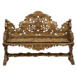 An Italian early 19th century carved limewood bench with a shaped high back conjoined by a floral