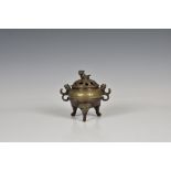 A Chinese bronze incense burner with compressed body, pierced reticulated decoration to cover,