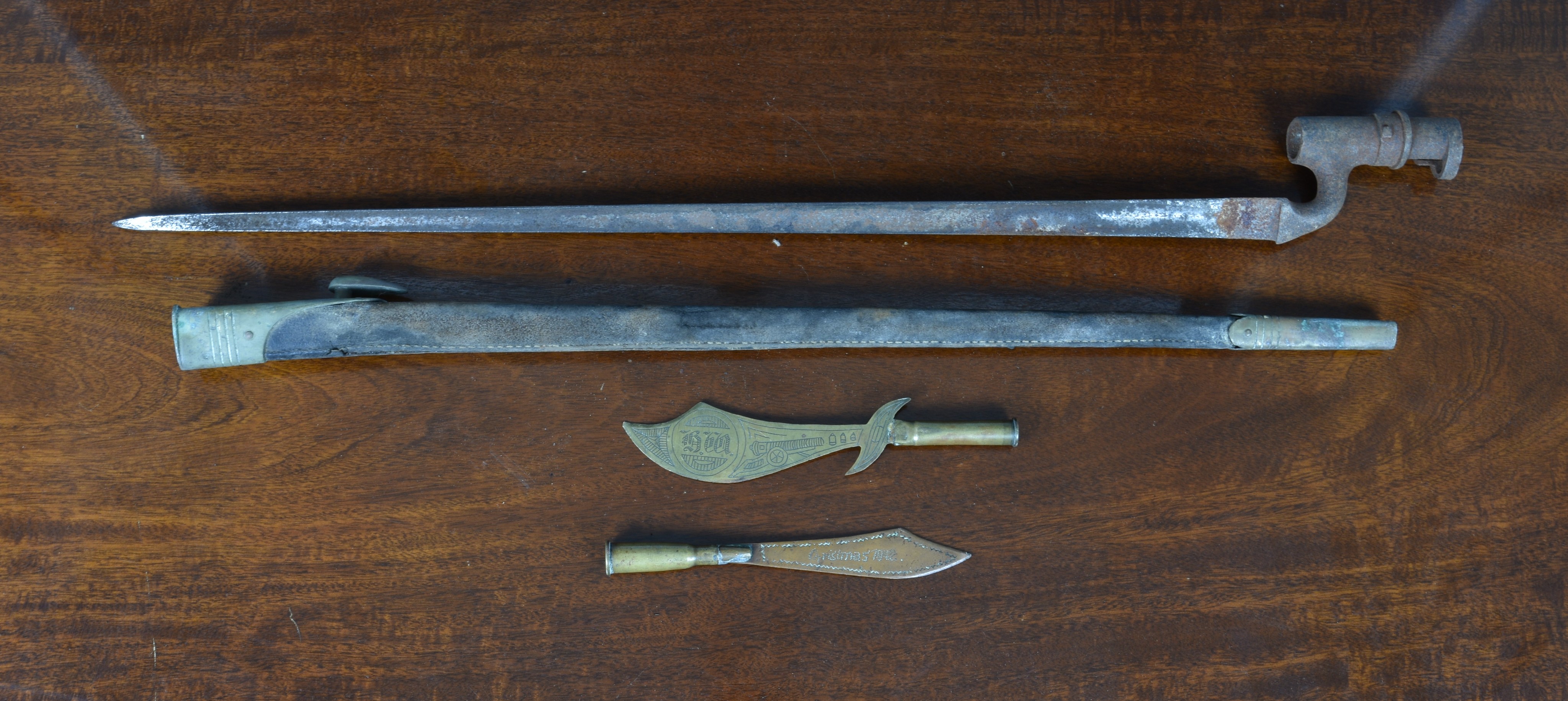 A British socket bayonet late 19th century, with brass and leather scabbard; together with two brass - Image 2 of 2