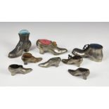 A small collection of antique pewter pin cushions fashioned as shoesof varying types and sizes,