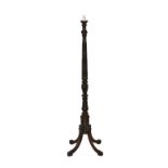 A George III style mahogany standard lamp 1920's, the heavily carved column on four swept legs