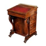 An early Victorian rosewood Davenport the top with gilt brass three quarter gallery over gilt tooled