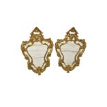 A pair of giltwood cartouche shaped mirrors in the Baroque style.
