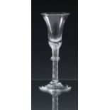 A mid-18th century tall airtwist wine glass c.1750, the bell shaped bowl on a slightly tapered multi