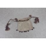 A Victorian style silver coin purse with silk corded drawstring top and wooden bead fringe.