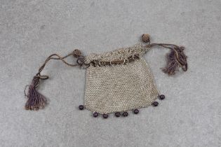 A Victorian style silver coin purse with silk corded drawstring top and wooden bead fringe.