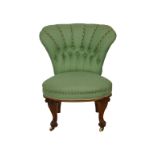 A Victorian green upholstered nursing chair button back, with C-scroll carved legs on brass