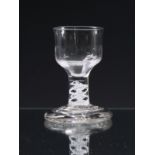 A mid-18th century opaque twist firing glass c.1765, the ogee bowl with moulded basal fluting, on