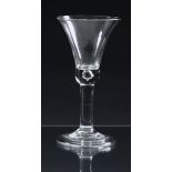 A mid-18th century wine glass c.1745, the waisted bell bowl with a solid base with tear, on a