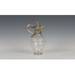 A Victorian cut and etched glass claret jug with silver plated mount having ribbed scroll handle