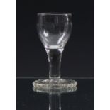 A mid-18th century dram glass with oversewn foot c.1765, the ovoid bowl with moulded half-fluted