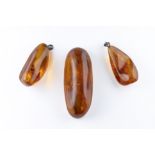 Two amber specimens containing winged insect inclusions one of elongated oval form with one flat cut