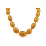 A single strand graduated amber bead necklace mid-20th century, comprising thirty-one oval amber