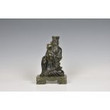 An Oriental green hardstone figure of a deity / scholar sitting upon a raised platform, 7 3/8in. (