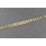 A 9ct yellow and white gold articulated bracelet, central channel of white gold links flanked by two