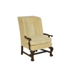 A Victorian wingback armchair the upholstered back to out swept scroll carved arms, raised on carved