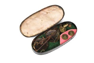 A set of steel, hanging, pocket-scales and weights, circa 1800, in an oval, black tole ware case,