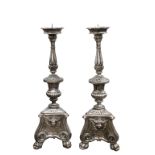 A pair of large Italian carved wooden floor-standing church candlesticks with recent silvered gilt