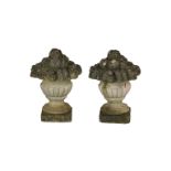 A pair of composite stone urns of fruit.