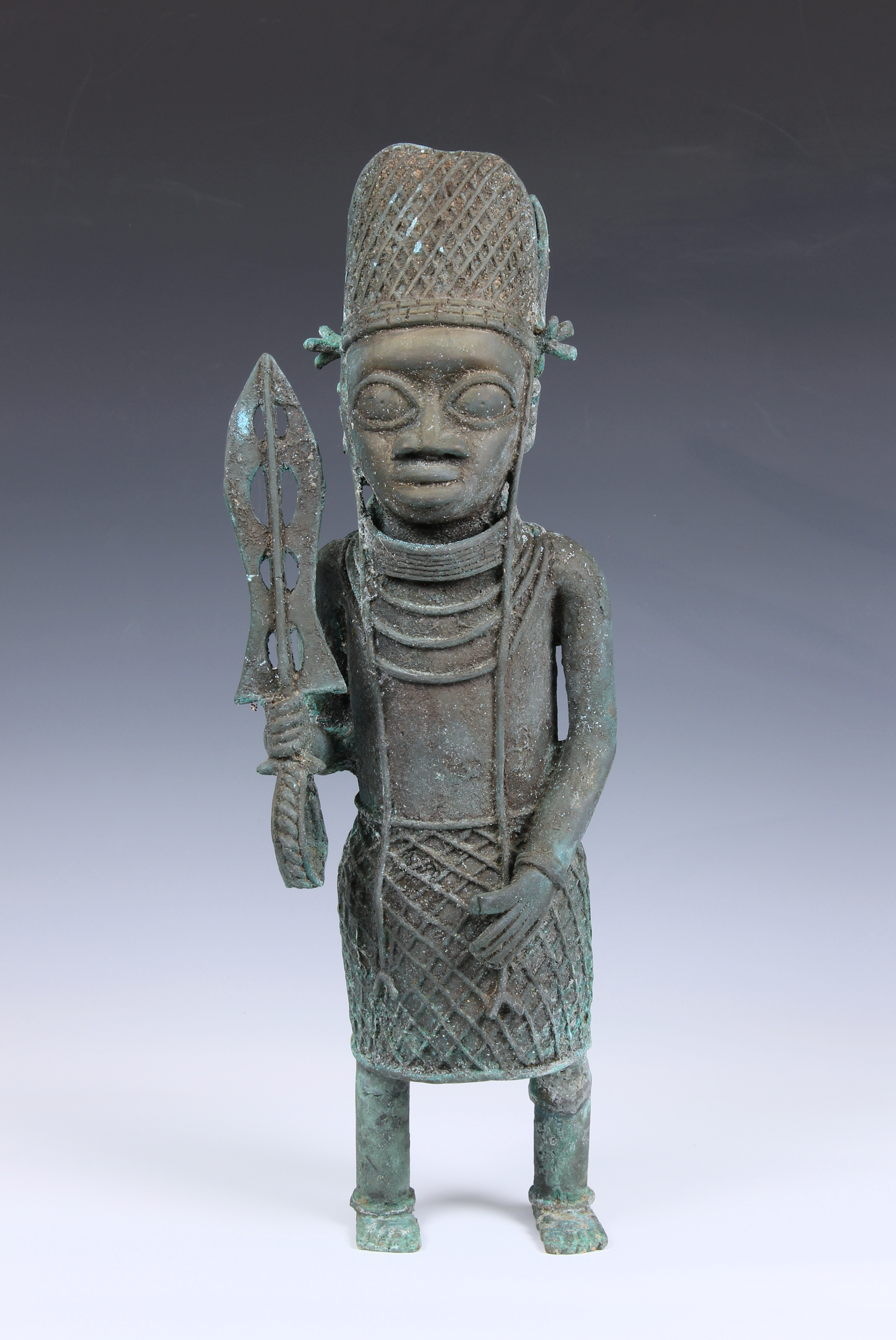 A large Benin style Nigerian bronze figure of an warrior 20th century, standing holding a sword with