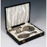 A cased silver brush and mirror set WI Broadway & Co, Birmingham, 1964, embossed with foliate scroll