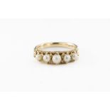 A vintage 18ct gold and five pearl ring the carved scroll setting holding five graduated pearls,