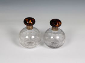 A pair of cut glass spherical perfume bottles with silver gilt necks